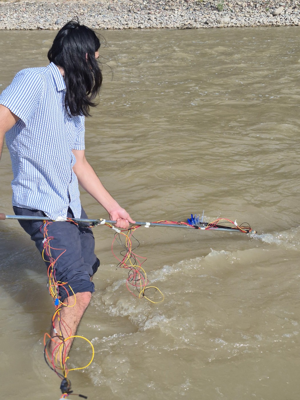 CanalSense team member wading the Colorado River with a node during a field test
